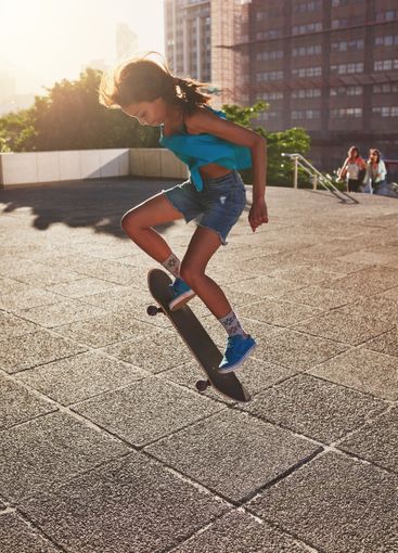 Skateboard, city and girl with ollie flip in air for...