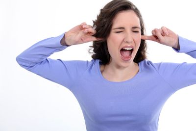 Woman stood with fingers in ears