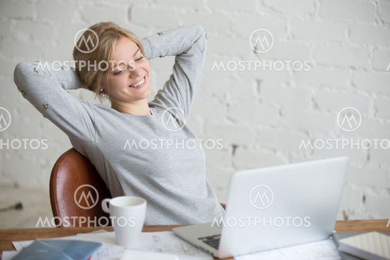 Portrait of smiling student girl, her arms behind her head