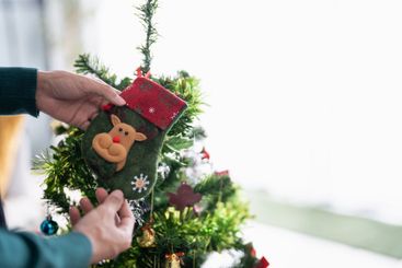 Happy hands Decorating Christmas tree for xmas holiday.