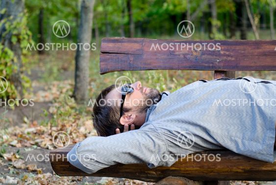 Man sleeping on a wooden bench