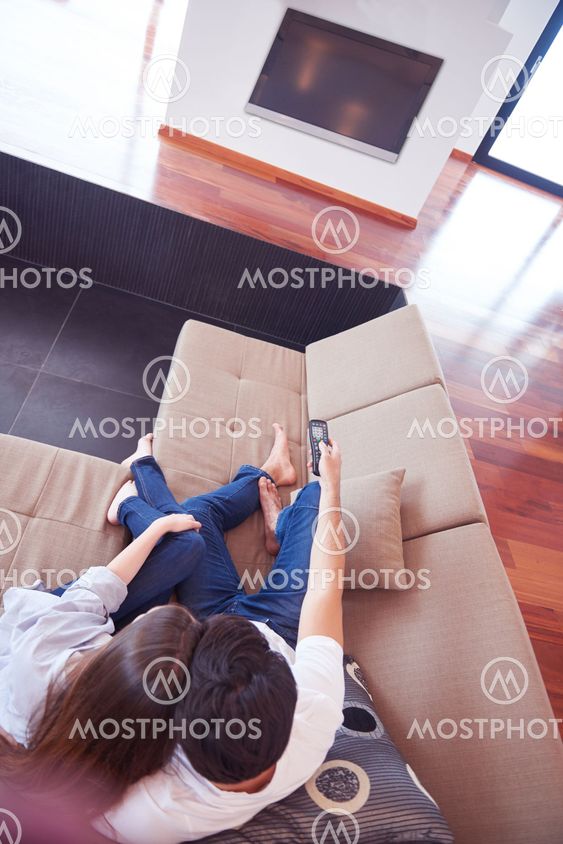 young couple watching tv at home