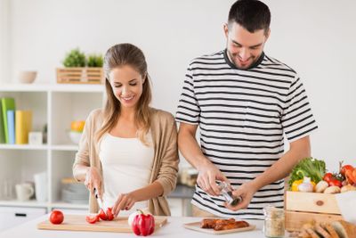 happy couple cooking food at home kitchen