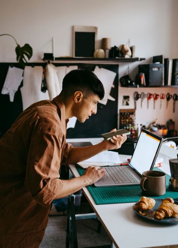 Side view of male freelancer doing multi-tasking with...