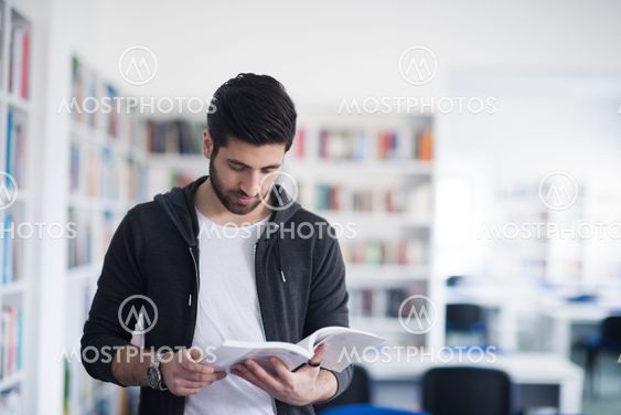 portrait of student while reading book in school library