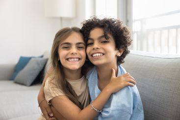 Close up portrait, two beautiful siblings laugh, look at...