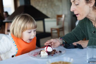 surprised face child eating cake with mother