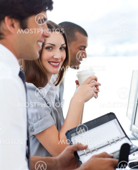Attractive businesswoman with her team drinking coffee