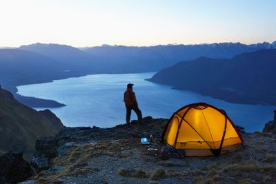 Man By Lake And Tent At Dusk