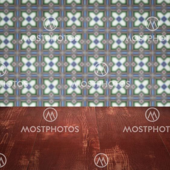 Wood table top and blur vintage ceramic tile pattern wall