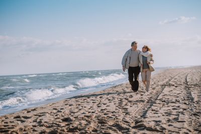 senior couple walking on seashore