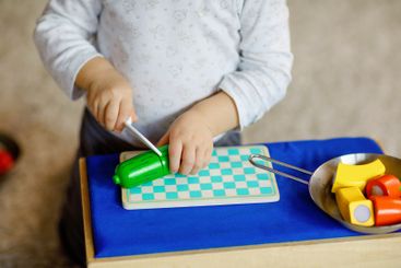 Cute little toddler girl playing at home with eco wooden...