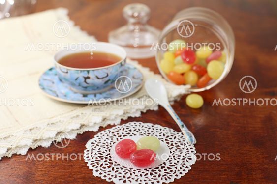 Tea with coloured sugar candies in a glass can