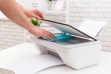 Person using a scanner to copy a document in a bright...