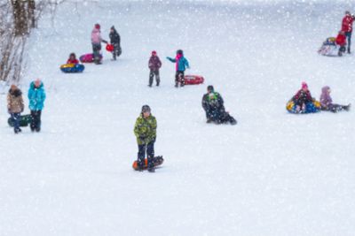 Children of sledding down a hill . Concepts active...