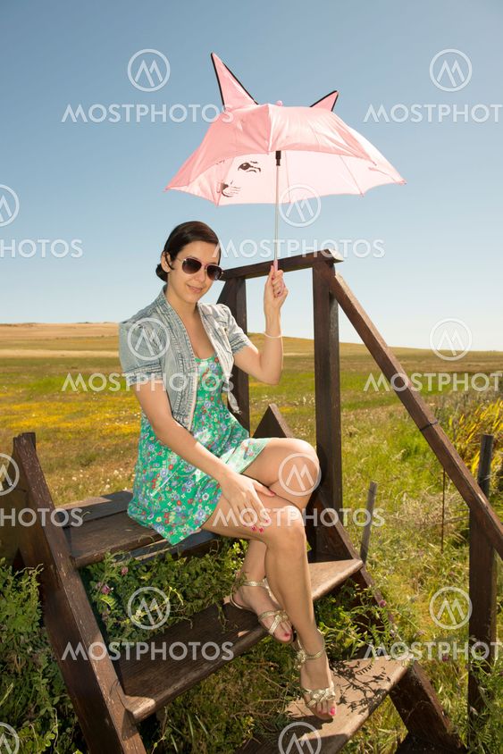 Beautiful adult smelling flowers on sunny field enjoying herself