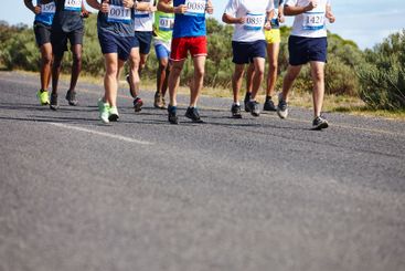 Marathon, legs and group running in road for...