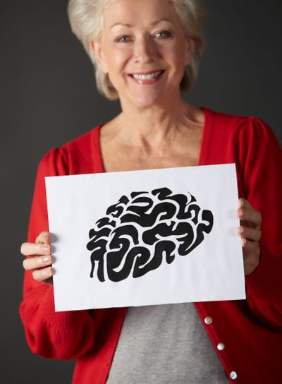 Senior woman holding ink drawing of brain