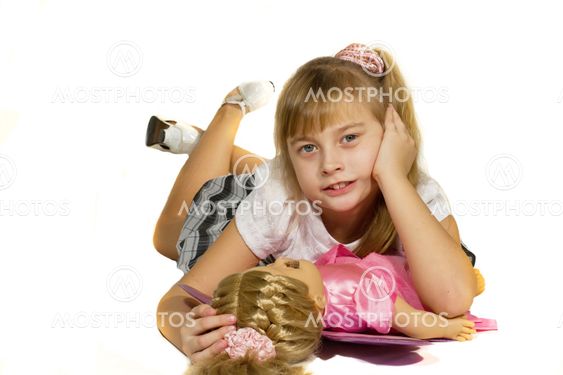 Beautiful little girl playing with a doll.