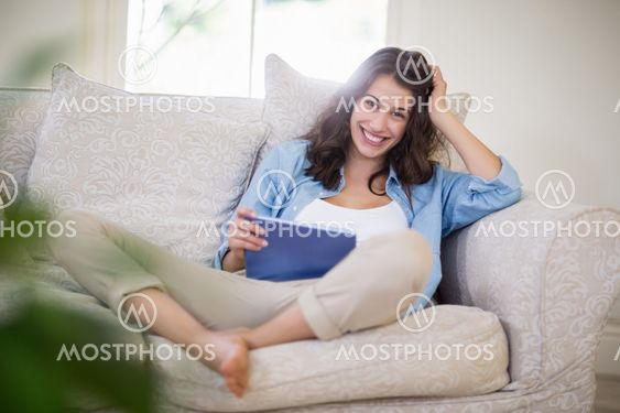 Woman using a digital tablet in living room