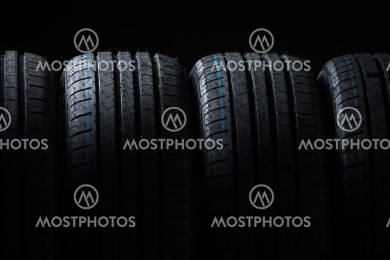 Stack of brand new high performance car tires on clean...