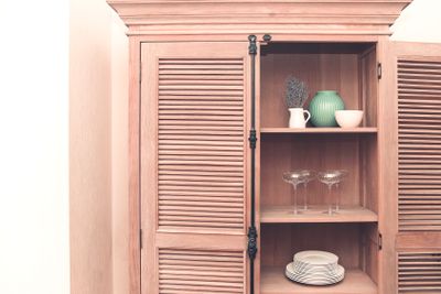 Kitchen cupboard with disheslike plates, tableclothes...