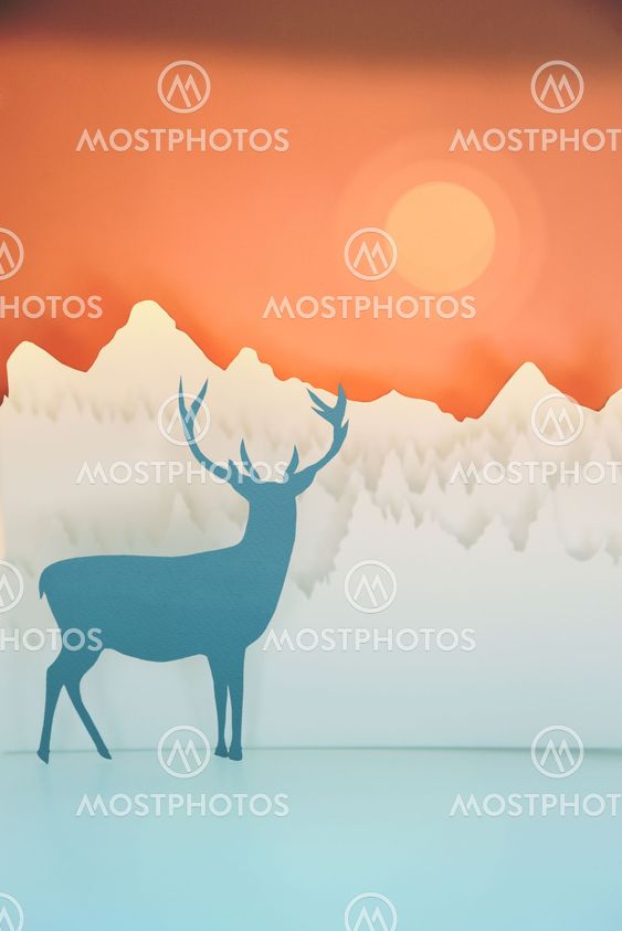 Holiday handmade paper cut deer forest sunset