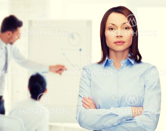 smiling businesswoman with crossed arms at office