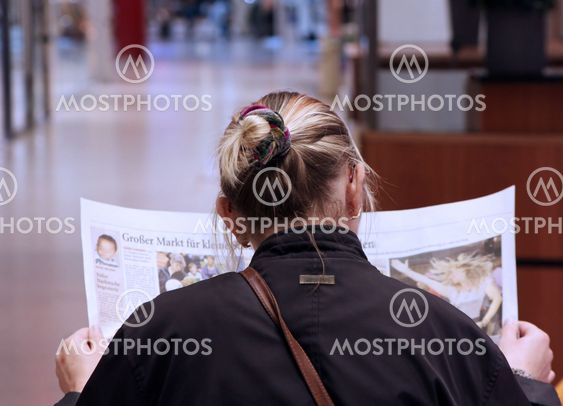 woman at the newspaper read