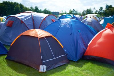 Group, colourful and camping tents in nature outside of...