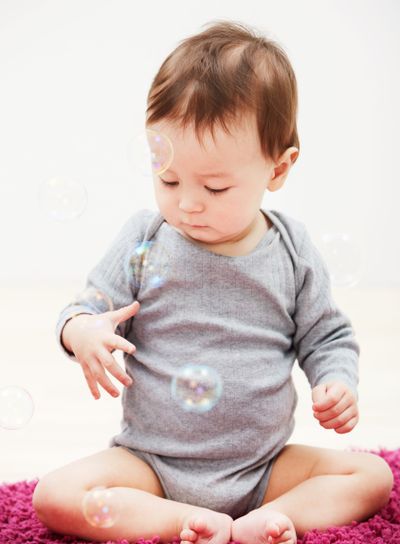 Baby, bubbles and playing game in home for childhood...