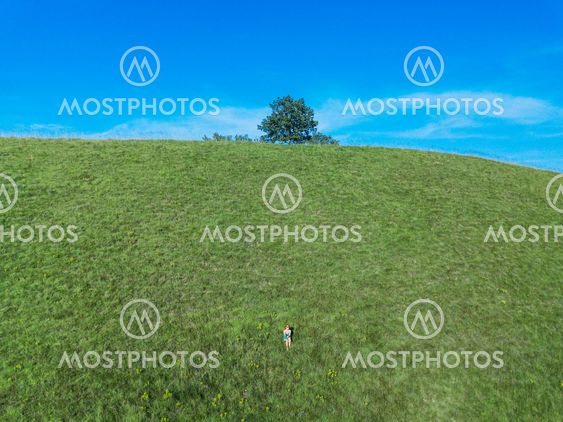 Young woman sitting on the hill enjoying nature