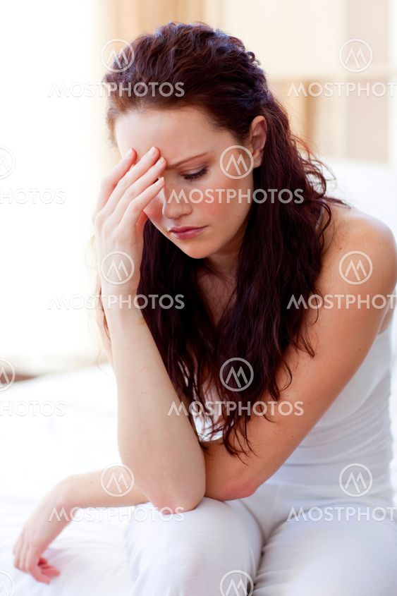 Beautiful woman having a headache in bed