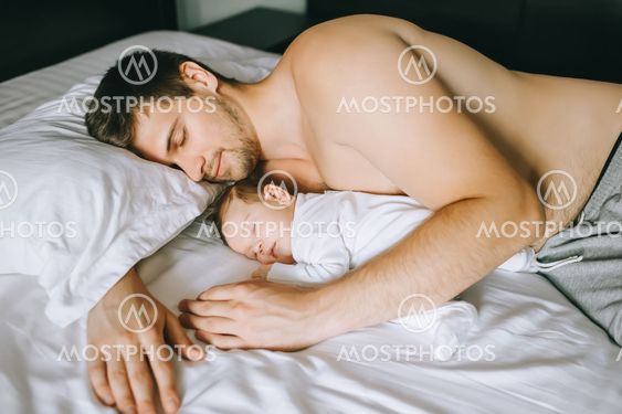 adorable little baby boy sleeping with shirtless father...