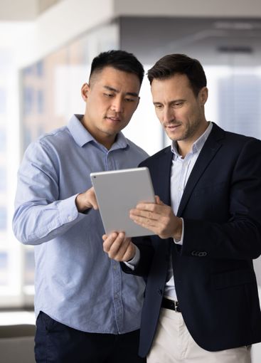 Focused diverse male business colleagues discussing...