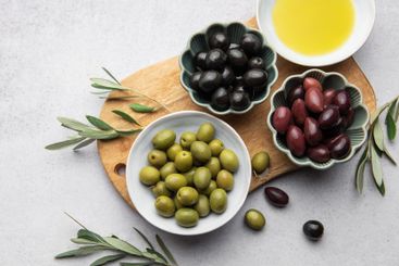 Variety of olives, olive oil, and olive branches served...