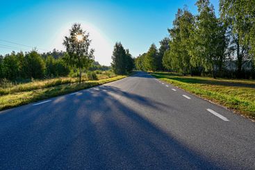 dimmig soluppgång över väg av asfalt 