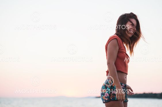 Young woman enjoying sunset by the sea
