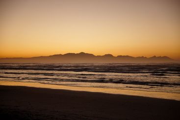 Sunset, mountains and ocean with waves, sky and tropical...