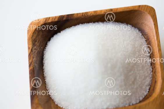 close up of white sugar heap in wooden bowl