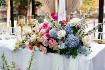 Vibrant floral arrangement graces elegant outdoor dining...