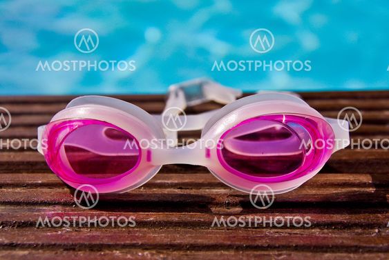 Swimming goggles on the edge of the pool.