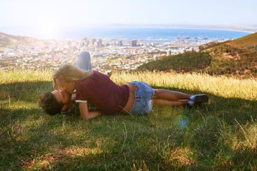 Couple, relax and kiss in nature for love, romantic date...