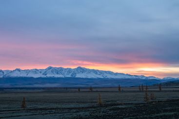 Distant view of high snowy mountains at dusk