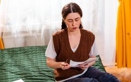 Portrait of young woman working on financial stability,...