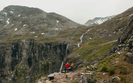 Father and daughter sitting on bench on mountain