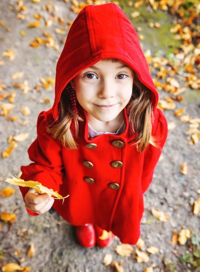 child in a red coat with autumn leaves. Love autumn....