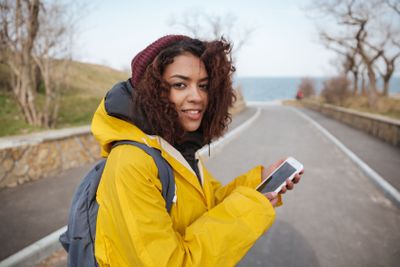 Woman near road using smartphone