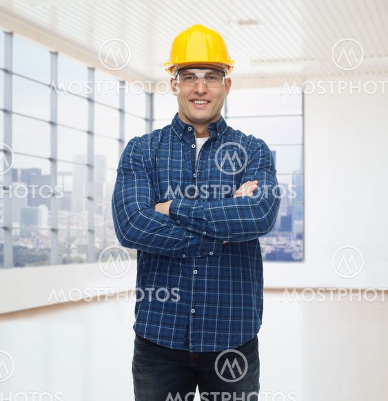 smiling male builder or manual worker in helmet