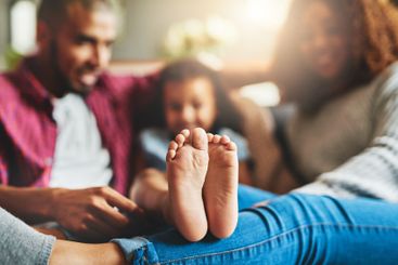 Feet, family and relax in living room, home and parents...